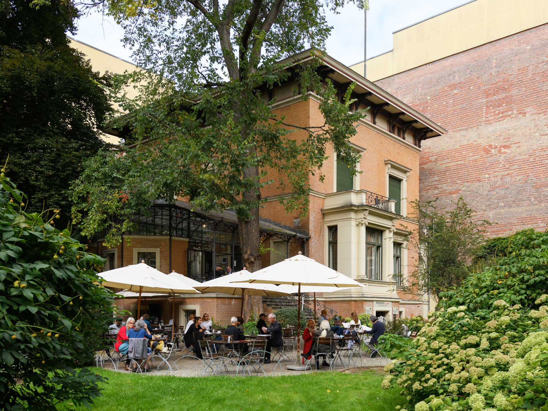 Blick auf den Garten des Literaturhaus Berlin und das gut besuchte Café.